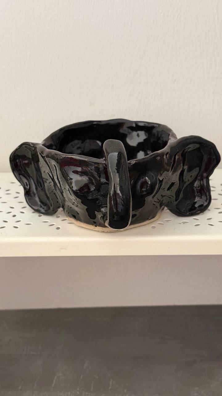 Schwarz glasierte Schale mit zwei flügelartigen Griffen und einem Steg, weiße Sprenkel